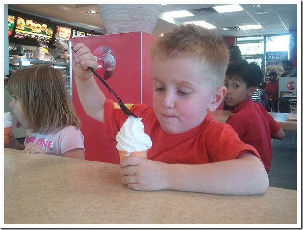 Henry eating icecream in a cone with a spoon